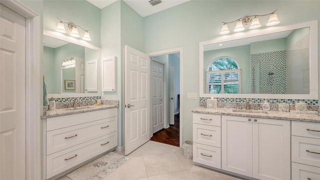 bathroom with an enclosed shower, vanity, tile patterned floors, and backsplash