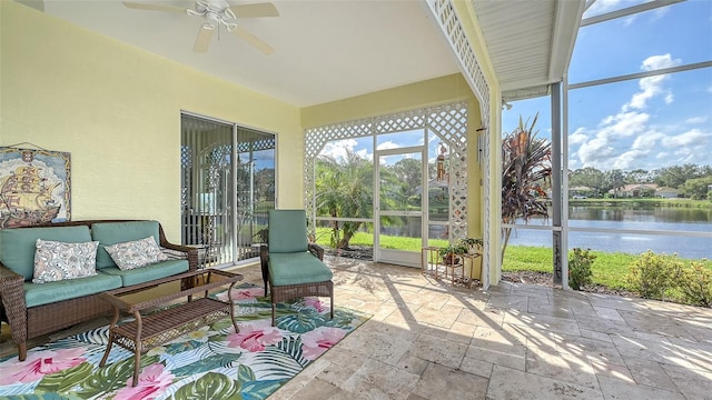 sunroom / solarium with a water view and ceiling fan