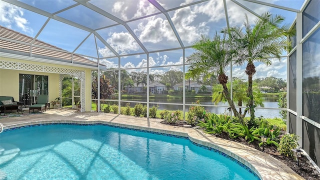 view of swimming pool with glass enclosure, a water view, and a patio area