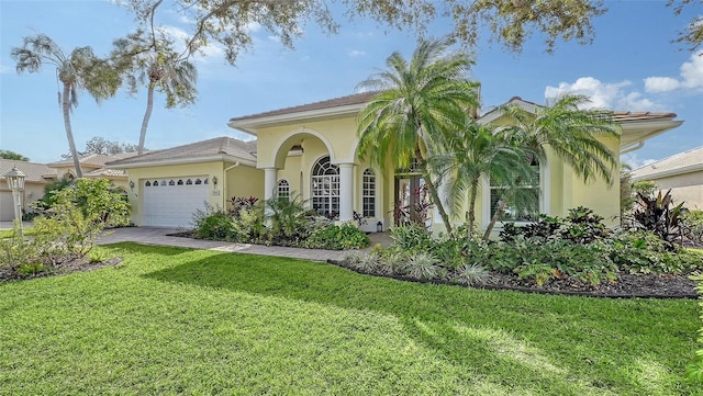 mediterranean / spanish house with a garage and a front yard