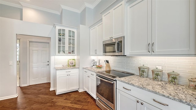 kitchen featuring dark hardwood / wood-style flooring, white cabinets, tasteful backsplash, light stone countertops, and appliances with stainless steel finishes