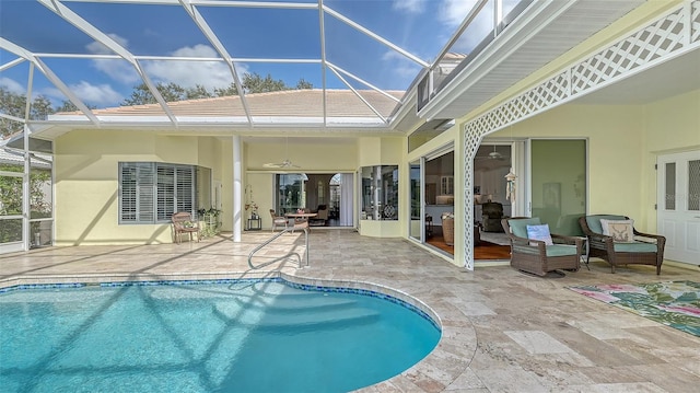 view of swimming pool with glass enclosure, a patio area, and ceiling fan