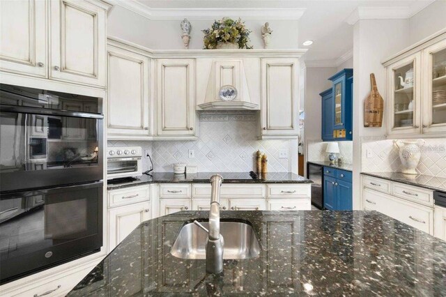 4561 Murcia Blvd Unit 13, Sarasota, FL 34238 - kitchen with black appliances, custom range hood, cream cabinetry, and crown molding