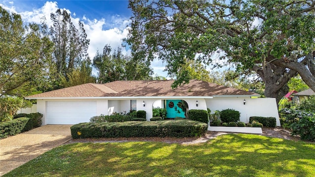 ranch-style house with a garage and a front yard