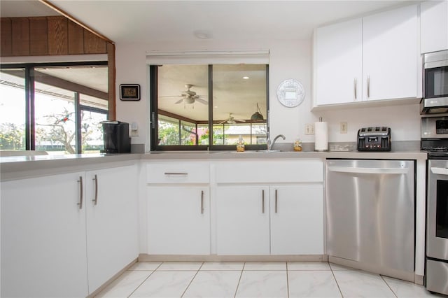 kitchen with stainless steel appliances, ceiling fan, and white cabinets