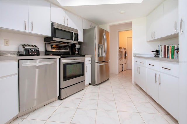 kitchen featuring washer and dryer, white cabinetry, light tile patterned floors, and appliances with stainless steel finishes