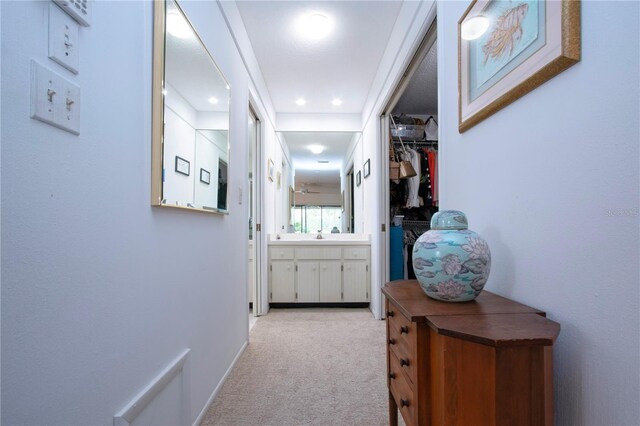 hallway featuring light colored carpet