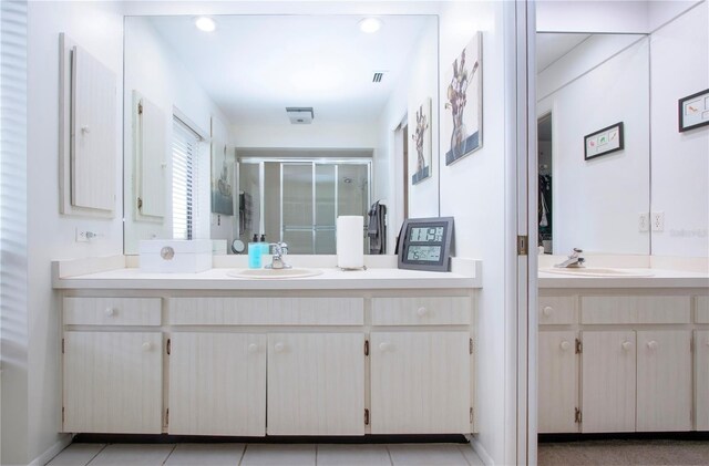 bathroom with vanity, a shower with door, and tile patterned floors