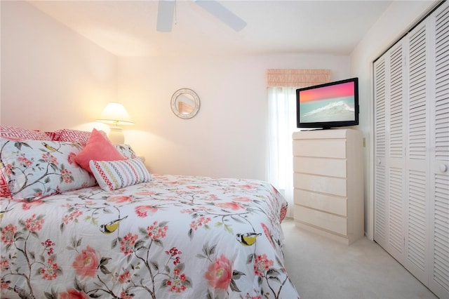 carpeted bedroom with ceiling fan and a closet