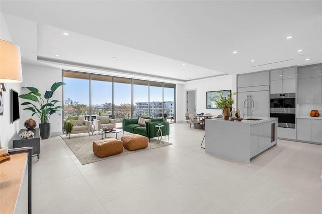 living room featuring sink and floor to ceiling windows