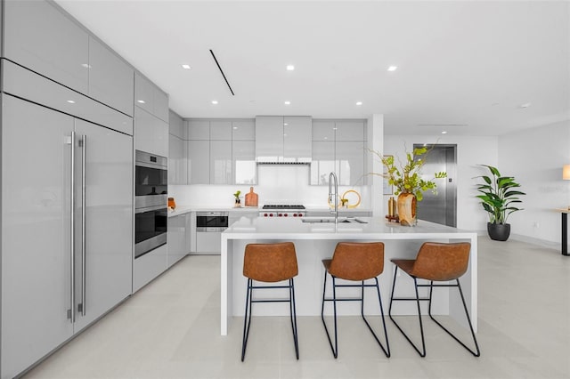 kitchen with a center island with sink, appliances with stainless steel finishes, a breakfast bar area, and sink