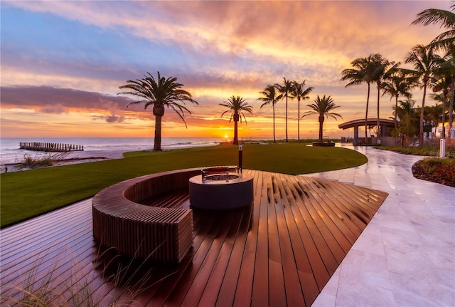 deck at dusk with a lawn, a gazebo, and a water view