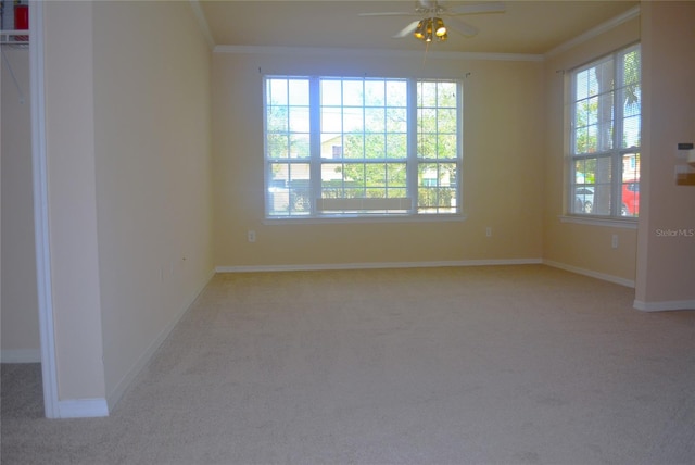 empty room featuring light carpet, ceiling fan, and crown molding