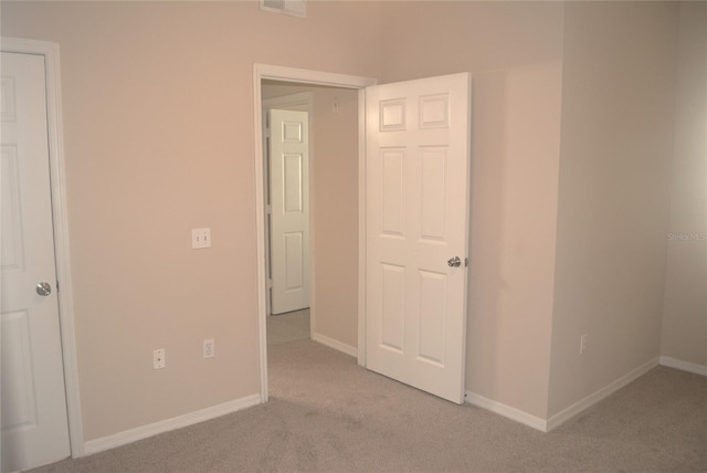 unfurnished bedroom featuring light carpet