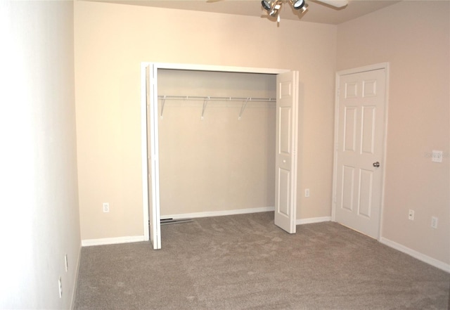 unfurnished bedroom featuring a closet and dark carpet