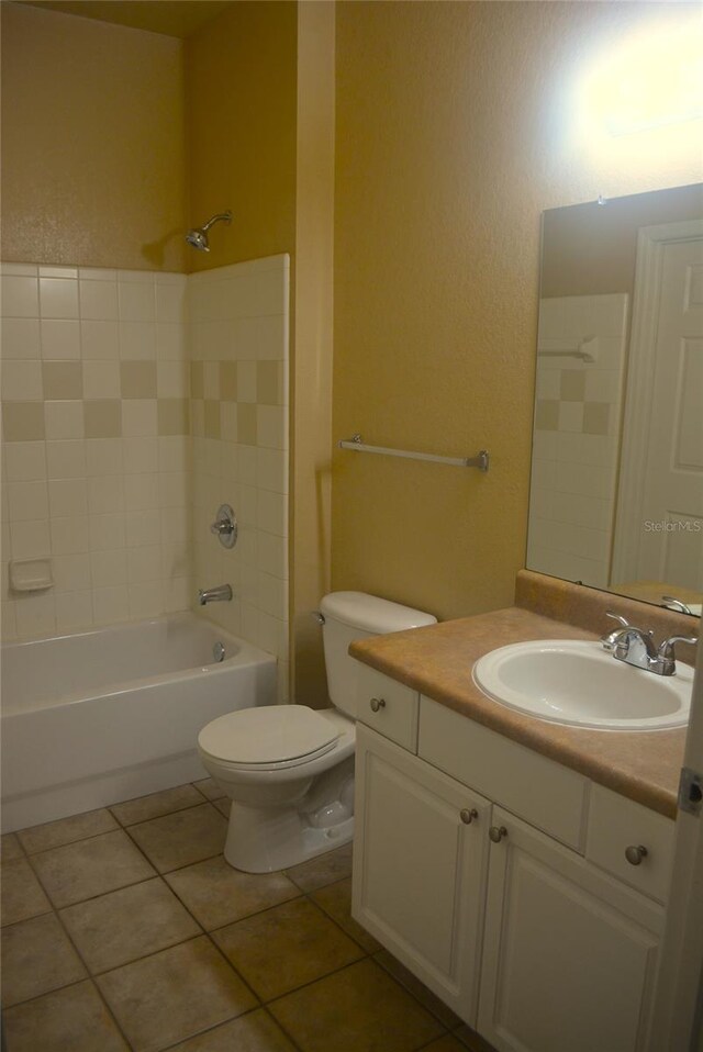 full bathroom featuring toilet, vanity, tiled shower / bath combo, and tile patterned floors