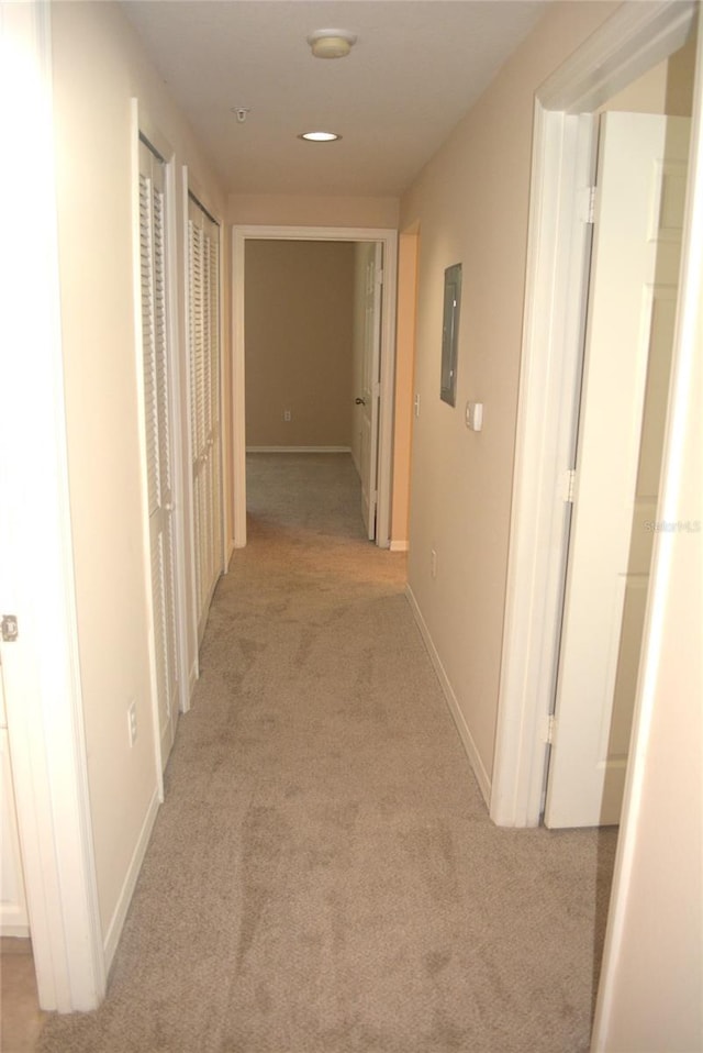 corridor featuring electric panel and light colored carpet