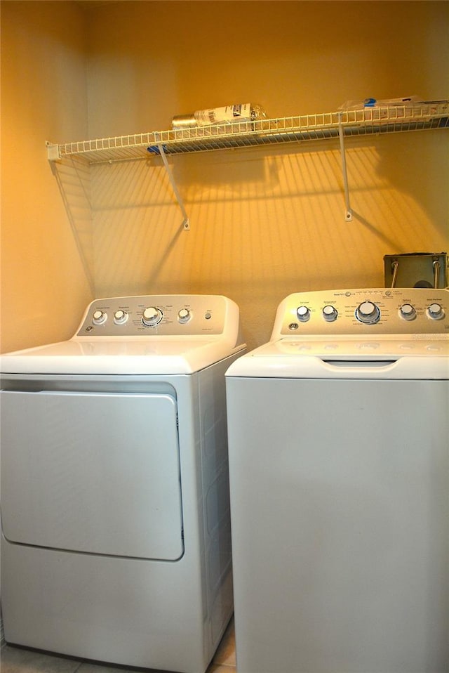 laundry room featuring separate washer and dryer and light tile patterned floors