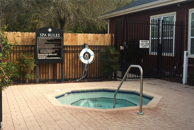 view of swimming pool with a hot tub