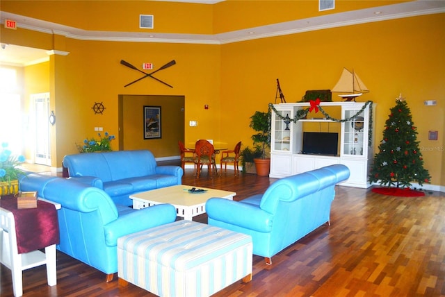 living room with a high ceiling, dark hardwood / wood-style floors, and crown molding