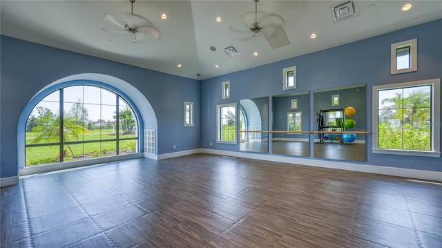 exercise room with ceiling fan and a towering ceiling