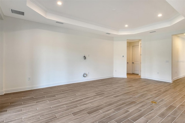 spare room featuring a tray ceiling and crown molding