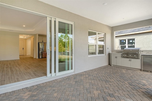 view of patio with area for grilling and sink