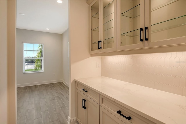 bar featuring light hardwood / wood-style floors and light stone countertops