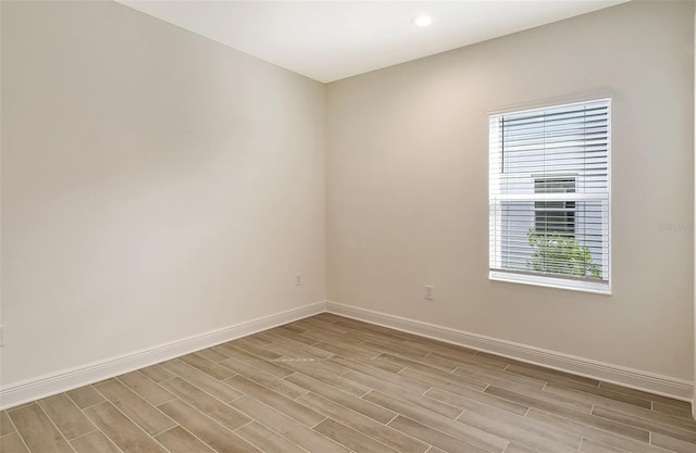 empty room featuring a healthy amount of sunlight and light hardwood / wood-style floors