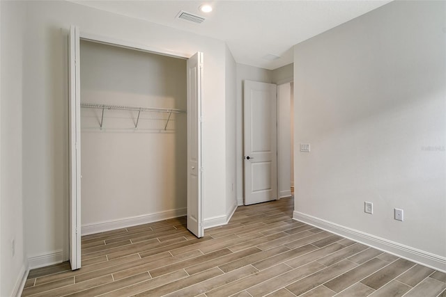 unfurnished bedroom with light wood-type flooring and a closet