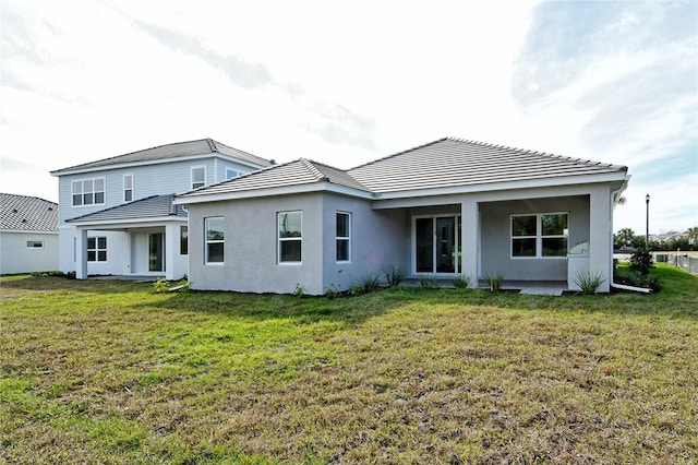 rear view of property featuring a lawn