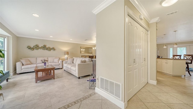 tiled living room with a healthy amount of sunlight and crown molding