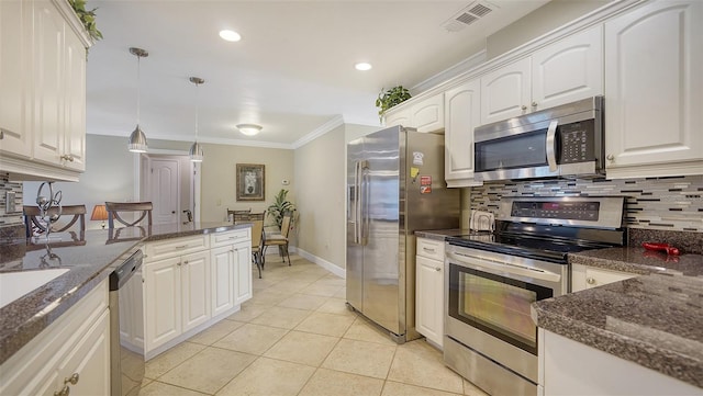 kitchen with white cabinets, stainless steel appliances, hanging light fixtures, and light tile patterned floors