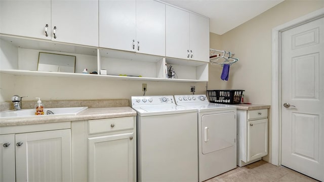 laundry room featuring washing machine and dryer, cabinets, sink, and light tile patterned flooring