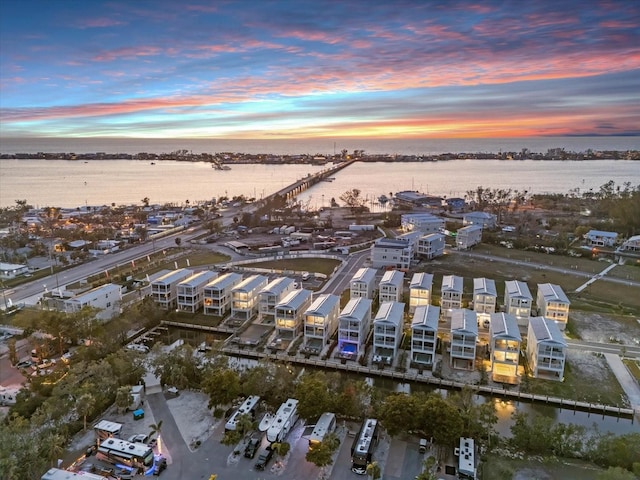 aerial view at dusk featuring a water view