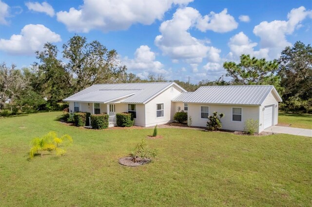 single story home with concrete driveway, metal roof, a garage, and a front lawn