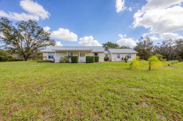 view of front of property featuring metal roof, a standing seam roof, and a front lawn