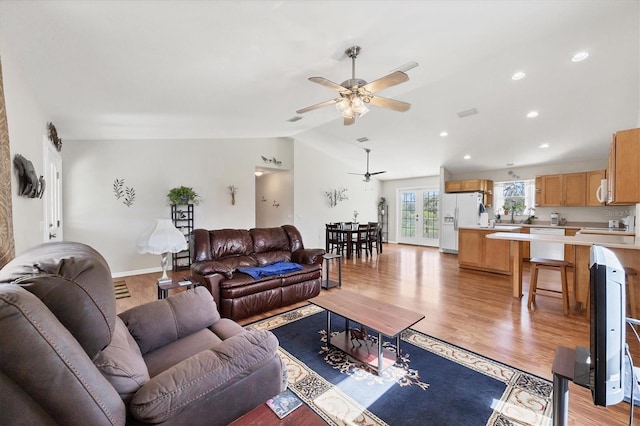 living area featuring light wood-style flooring, recessed lighting, baseboards, ceiling fan, and vaulted ceiling