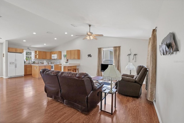 living area with lofted ceiling, recessed lighting, light wood-type flooring, and a ceiling fan