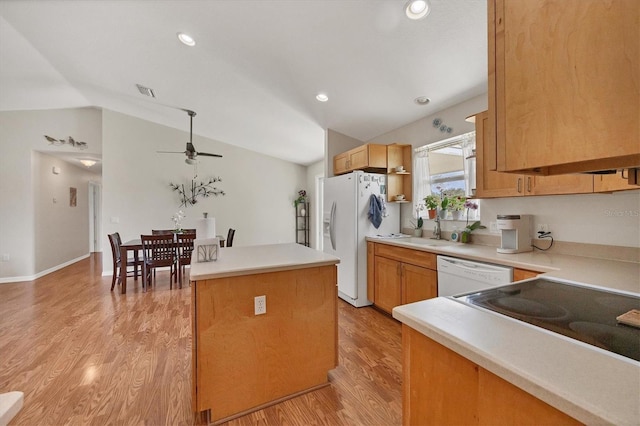 kitchen featuring vaulted ceiling, white appliances, ceiling fan, a kitchen island, and light wood-type flooring