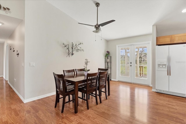 dining room with french doors, light hardwood / wood-style floors, ceiling fan, and vaulted ceiling