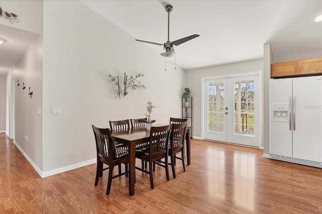 dining room with lofted ceiling, french doors, light wood-style flooring, baseboards, and ceiling fan