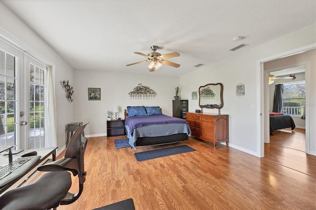 bedroom with access to exterior, french doors, light hardwood / wood-style floors, and ceiling fan