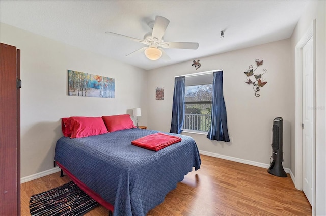 bedroom featuring wood finished floors, baseboards, and ceiling fan