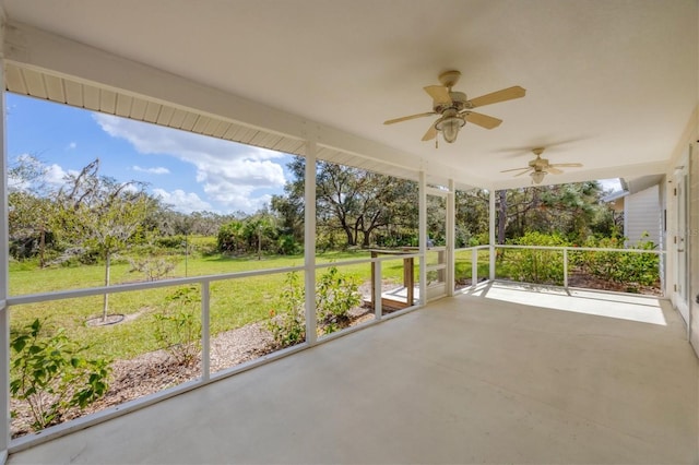 unfurnished sunroom featuring ceiling fan