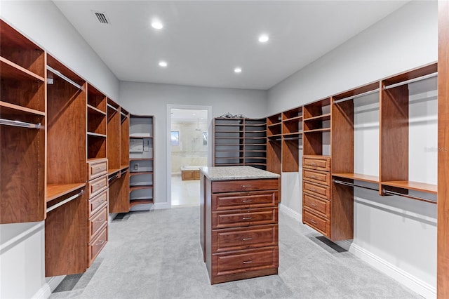 spacious closet featuring light carpet and built in desk