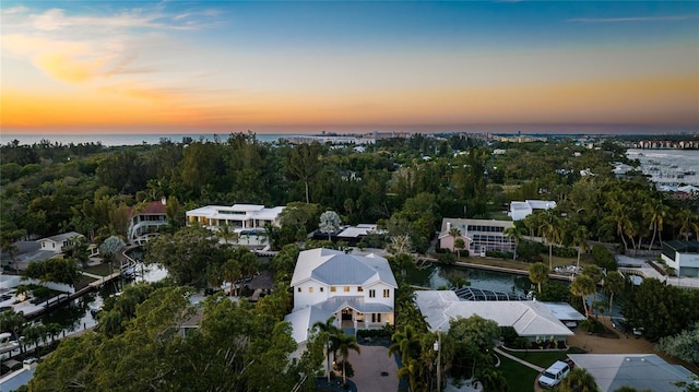 aerial view at dusk featuring a water view