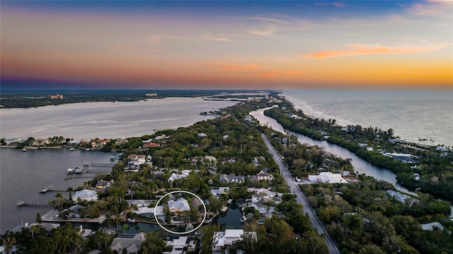 aerial view at dusk featuring a water view