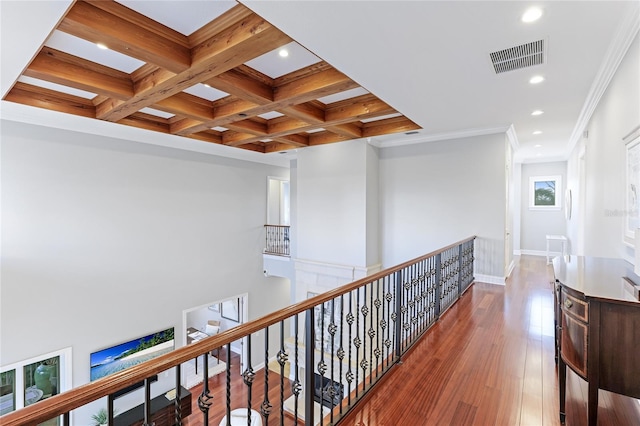 corridor featuring wood-type flooring, ornamental molding, beamed ceiling, and coffered ceiling