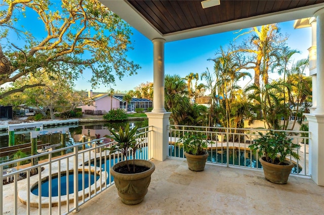 view of patio / terrace featuring an in ground hot tub and a balcony